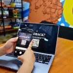 User Feedback - a person using a cell phone while sitting in front of a laptop