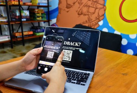 User Feedback - a person using a cell phone while sitting in front of a laptop