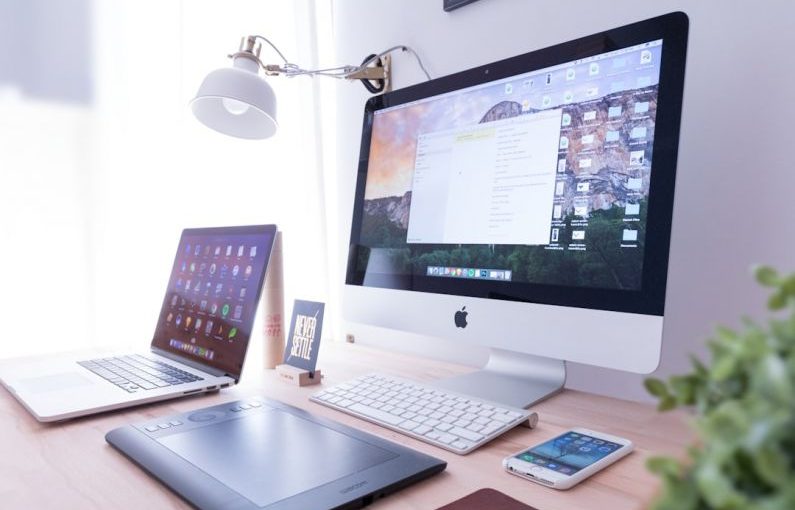 Responsive Design - silver iMac near iPhone on brown wooden table
