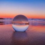Crystal Ball - clear glass ball on gray sand during sunset