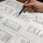 UX Design - person holding pen near paper