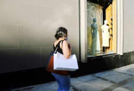 Shopping Behavior - woman in white shirt and blue denim jeans standing in front of mirror