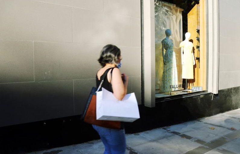 Shopping Behavior - woman in white shirt and blue denim jeans standing in front of mirror