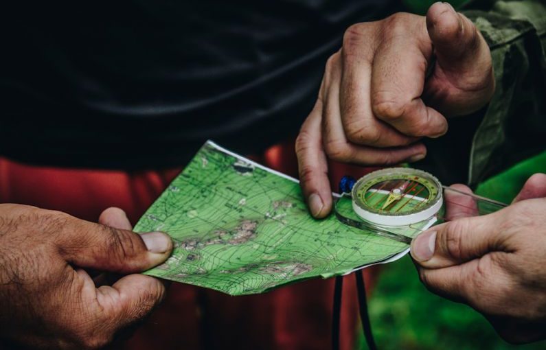 Local Map - two person holding map and clear compass