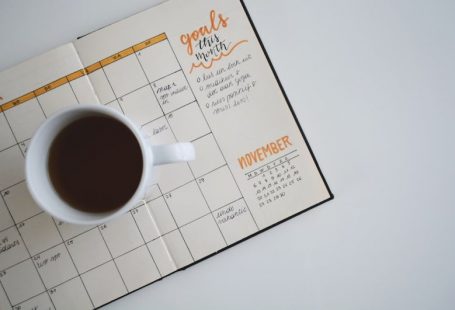 Content Calendar - white ceramic mug with coffee on top of a planner