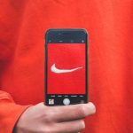 Brand Loyalty - person holding iPhone taking picture on Nike label