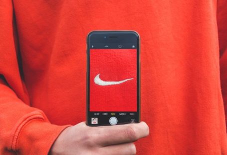 Brand Loyalty - person holding iPhone taking picture on Nike label