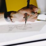 Logo Design - person lettering on tracing paper using mechanical pencil