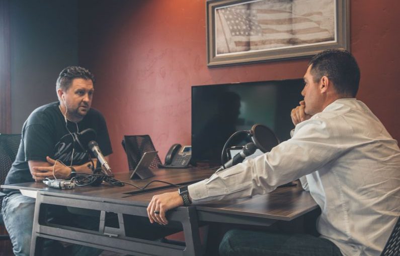 Podcast Marketing - man sitting in front of another man also sitting inside room